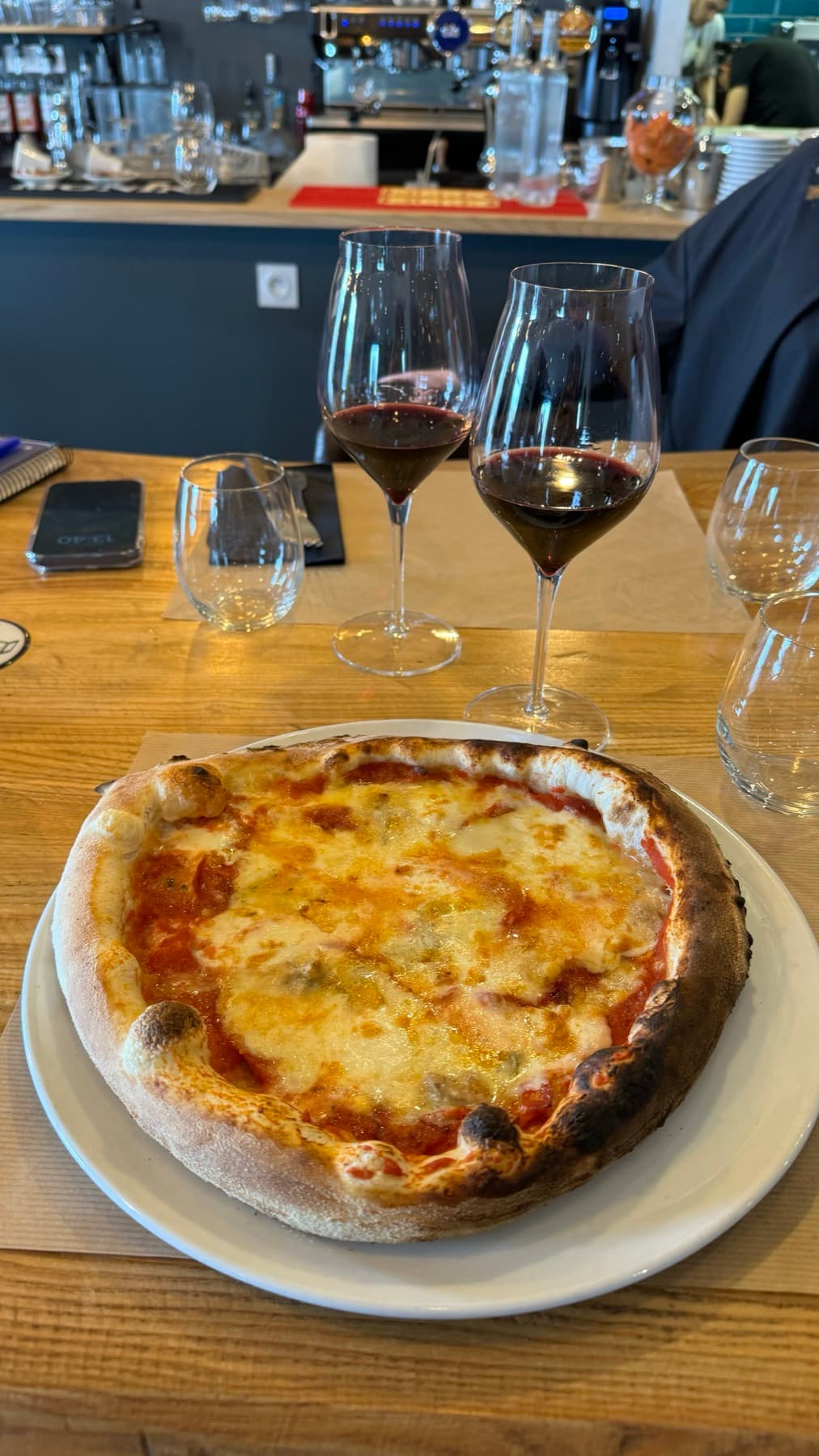 Pizza cuite au feu de bois et verres de vin rouge chez I Gusti Della Mamma